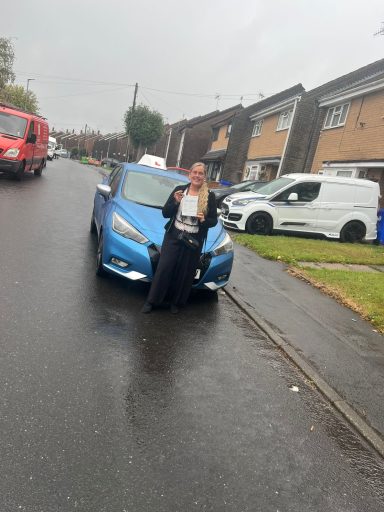 Someone standing in front of a blue car 