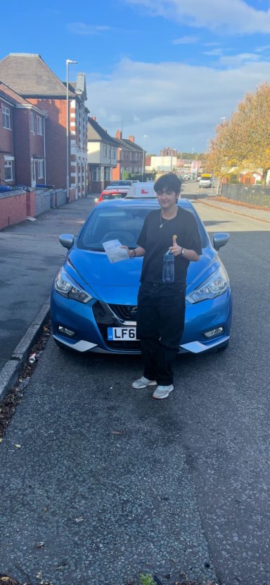 Someone standing in front of a blue car