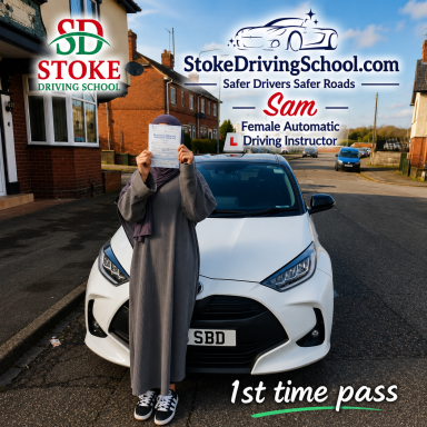 A person in a grey dress holds a certificate in front of a car with a driving school logo.
